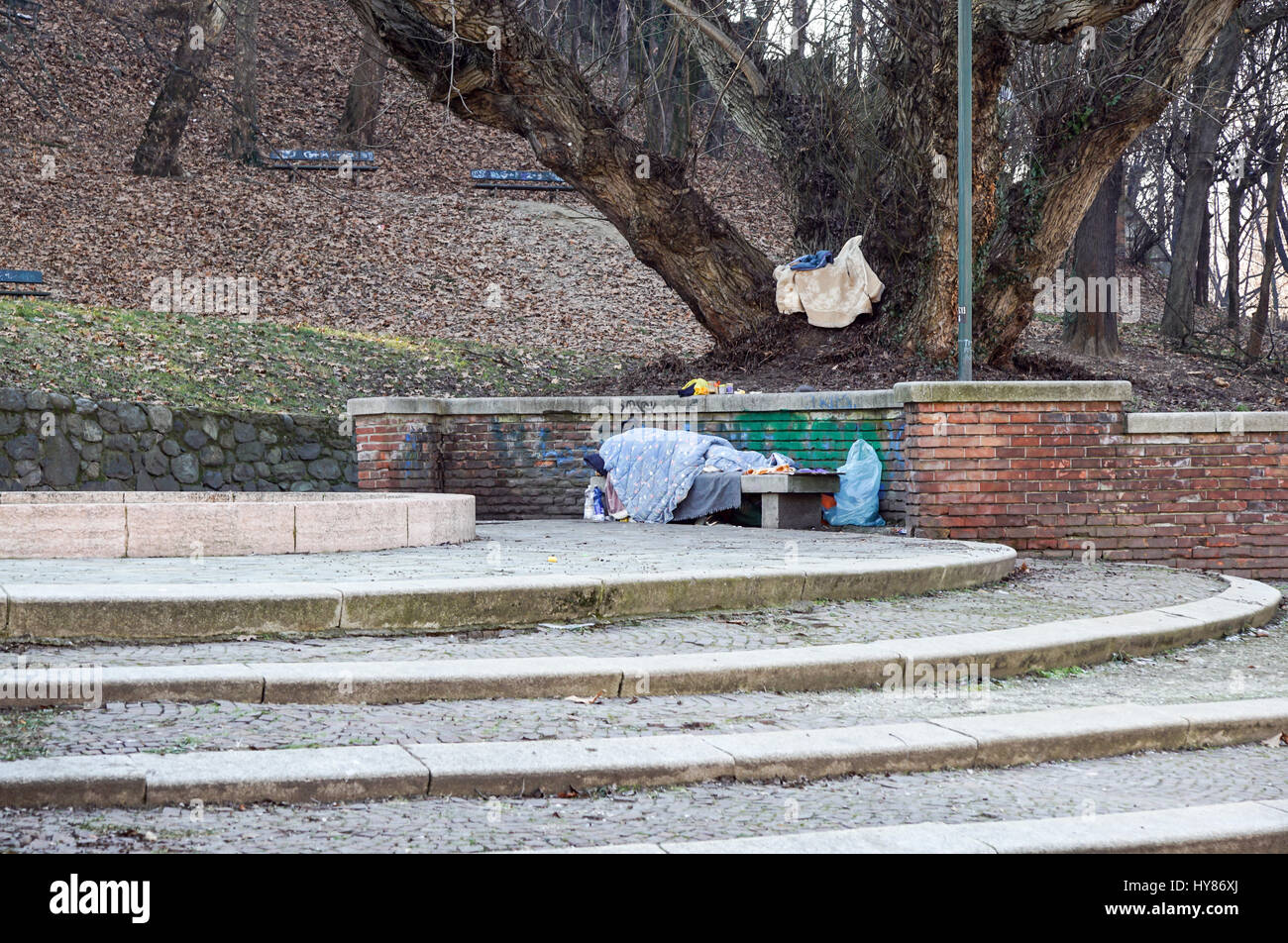 Homeless man sleeping peacefully on wooden bench Stock Photo - Alamy