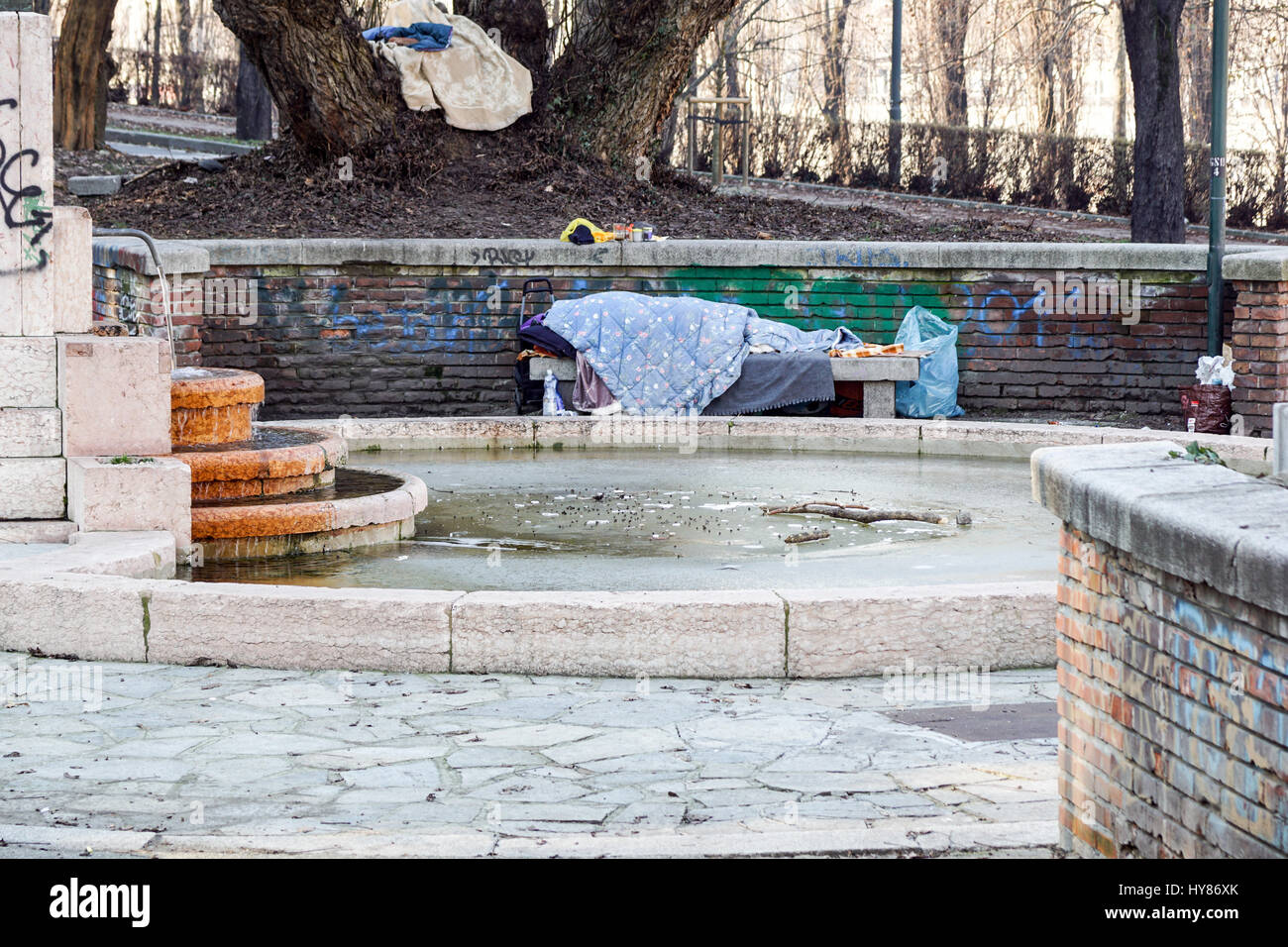Homeless man sleeping peacefully on wooden bench Stock Photo - Alamy