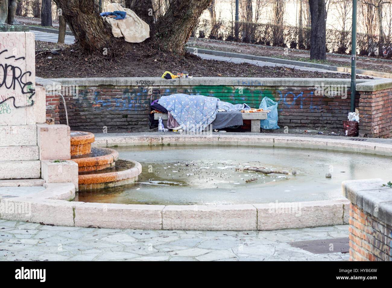 Homeless man sleeping peacefully on wooden bench Stock Photo - Alamy