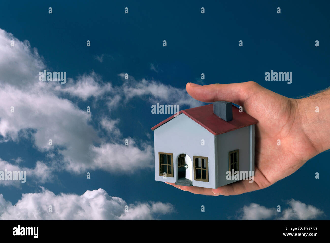 Model house on a white background with hand. Stock Photo