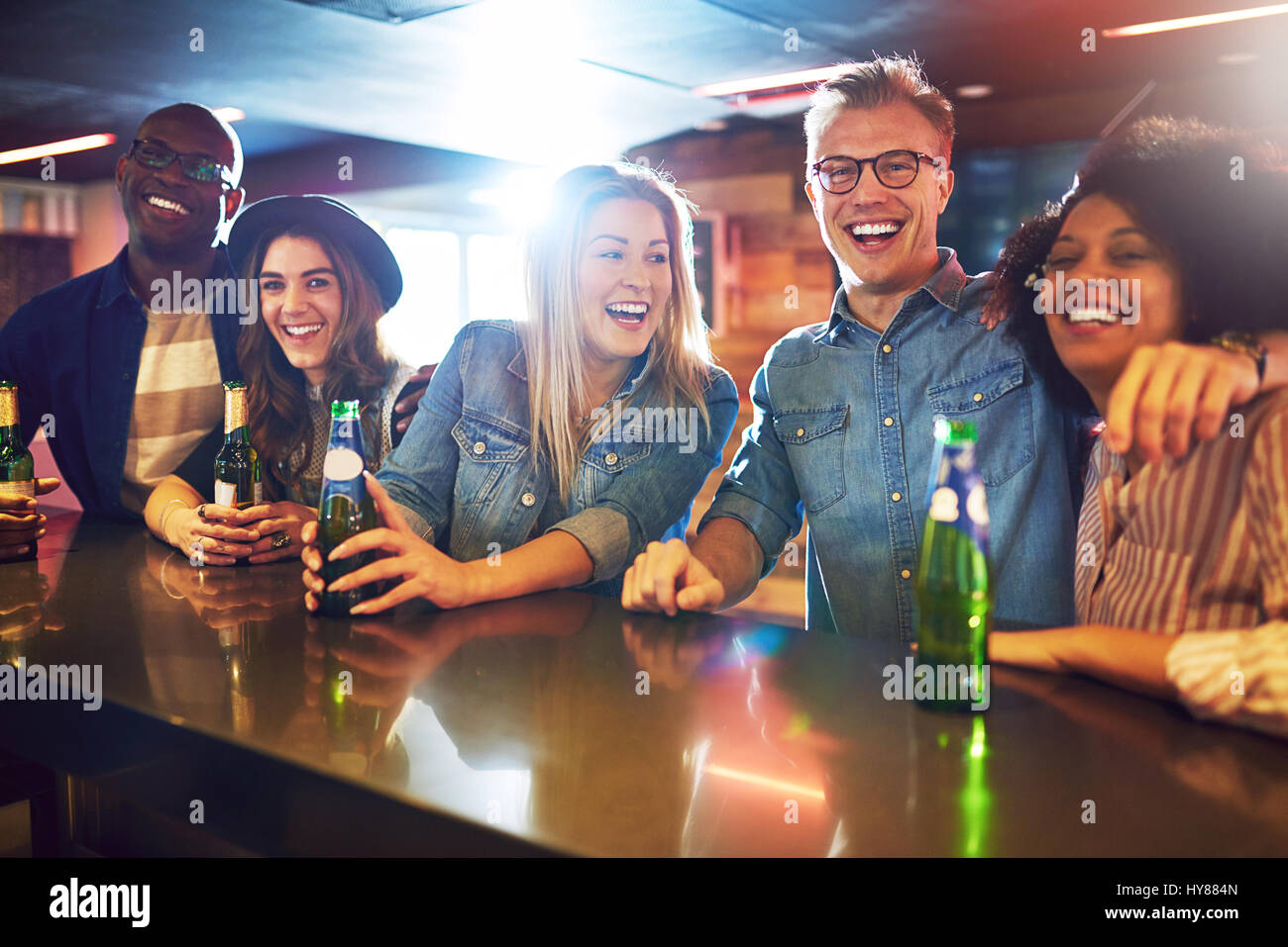 Smiley friendly people in the bar with a beer looking at camera. Friends and fun concept. Stock Photo