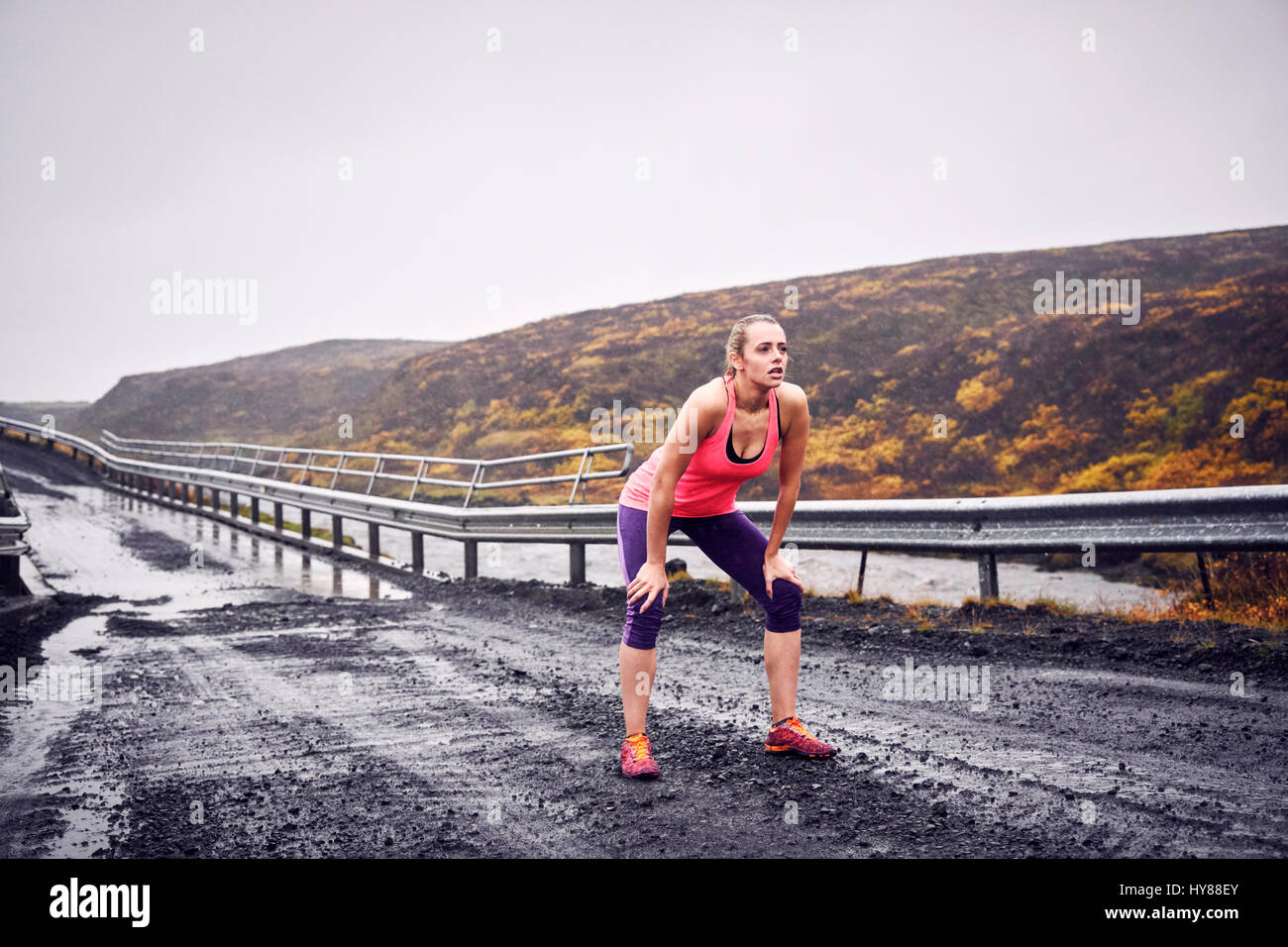 Young women resting after running over a bridge in stormy Iceland Stock Photo