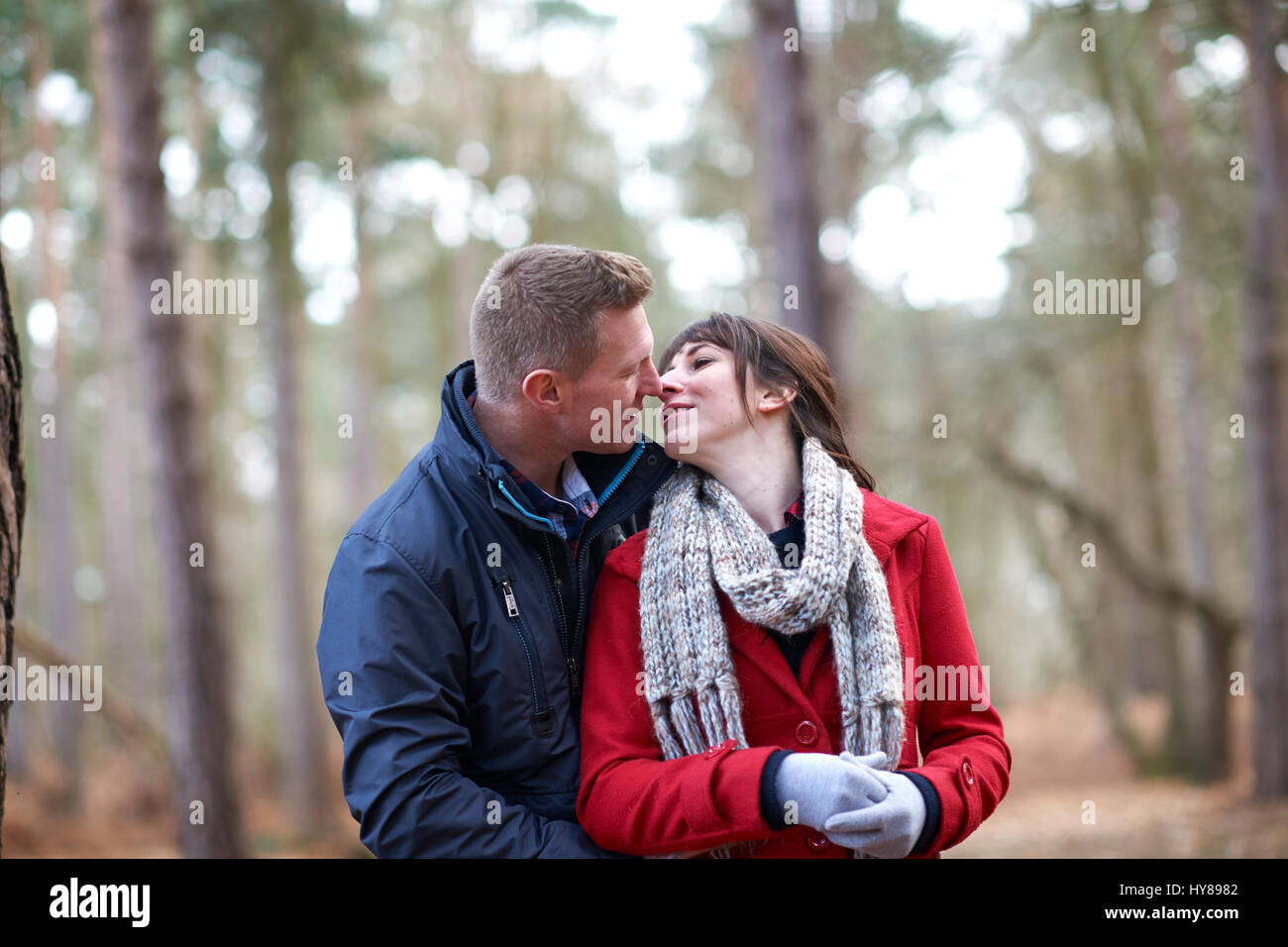 A young couple embrace during a walk in the woods Stock Photo - Alamy