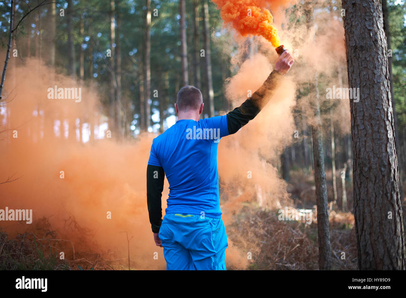 A man lets off a flare in the woods Stock Photo