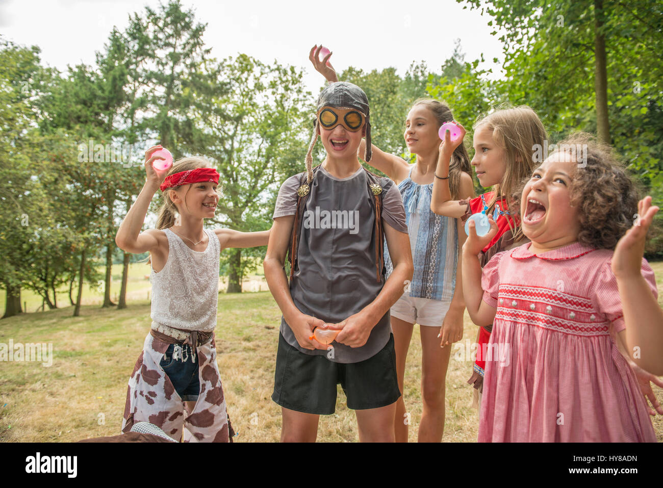 Young children play games outside in the sunshine Stock Photo