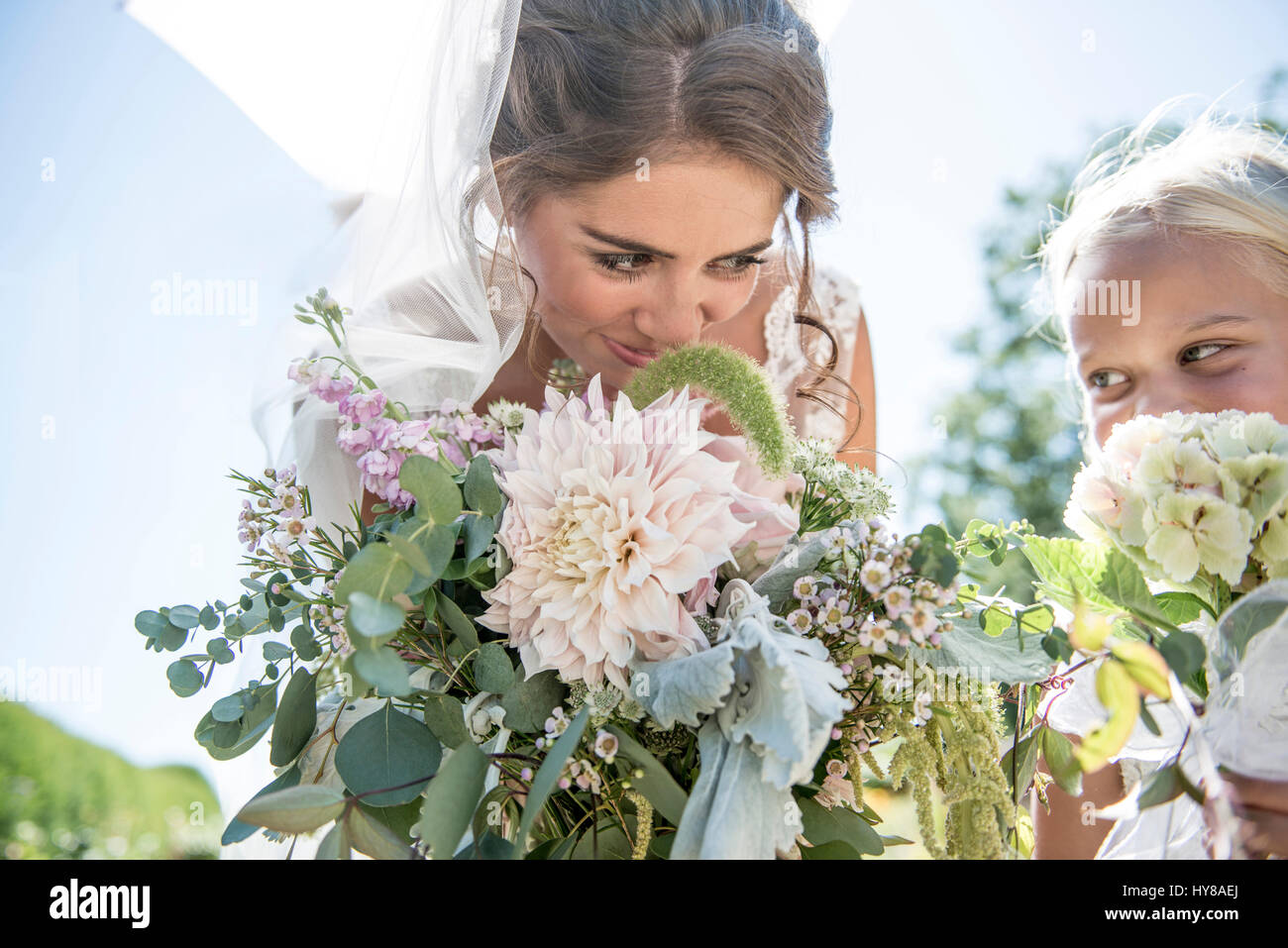A bride and her young bridesmaid with their bouquets Stock Photo