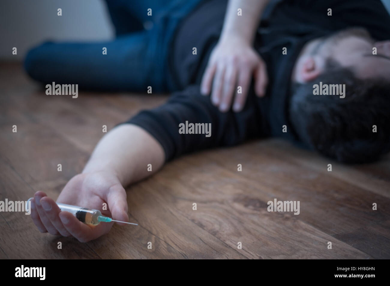 Man lying down on the floor after a drug overdose Stock Photo