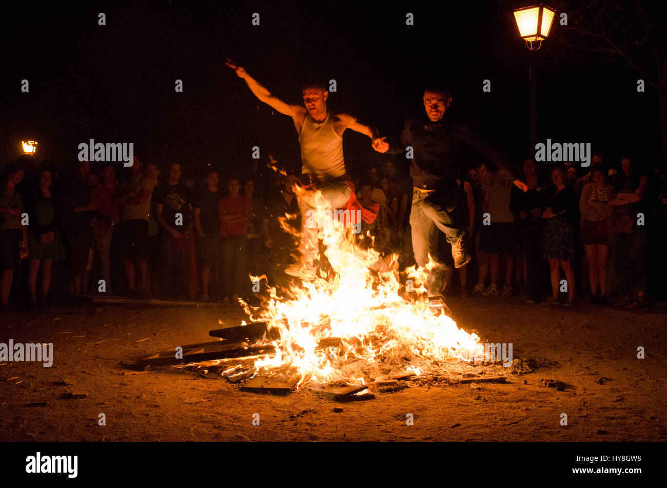 Two men jumping together over a bonfire during Saint John's Eve in
