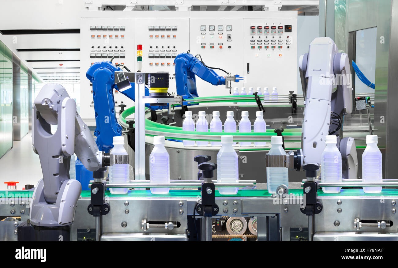 Robotic arm holding water bottles on production line in factory ...