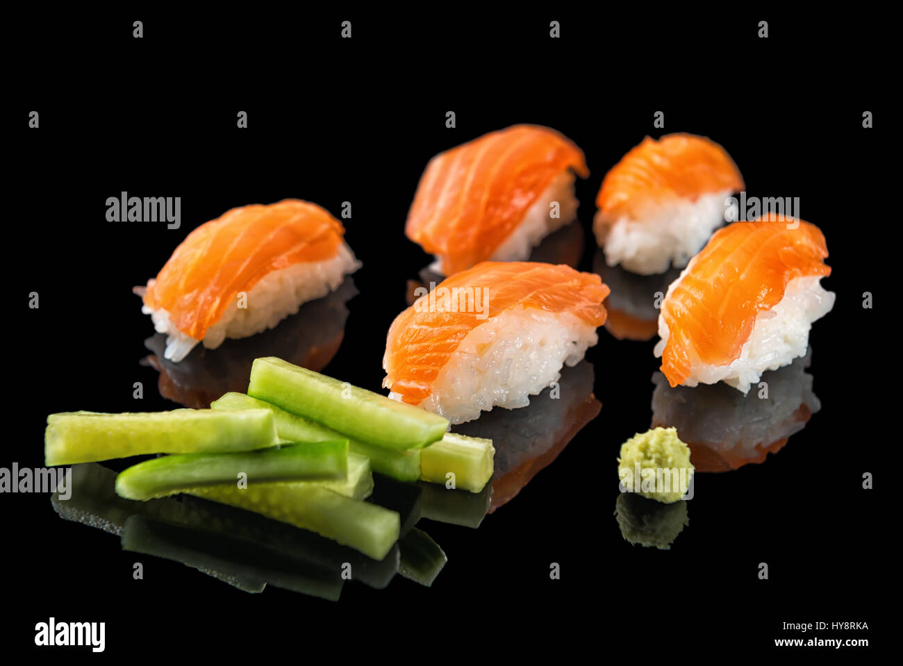 Japanese sushi nigiri with salmon and wasabi, cucumbers on black background with reflection, close up, concept of  healthy eating Stock Photo