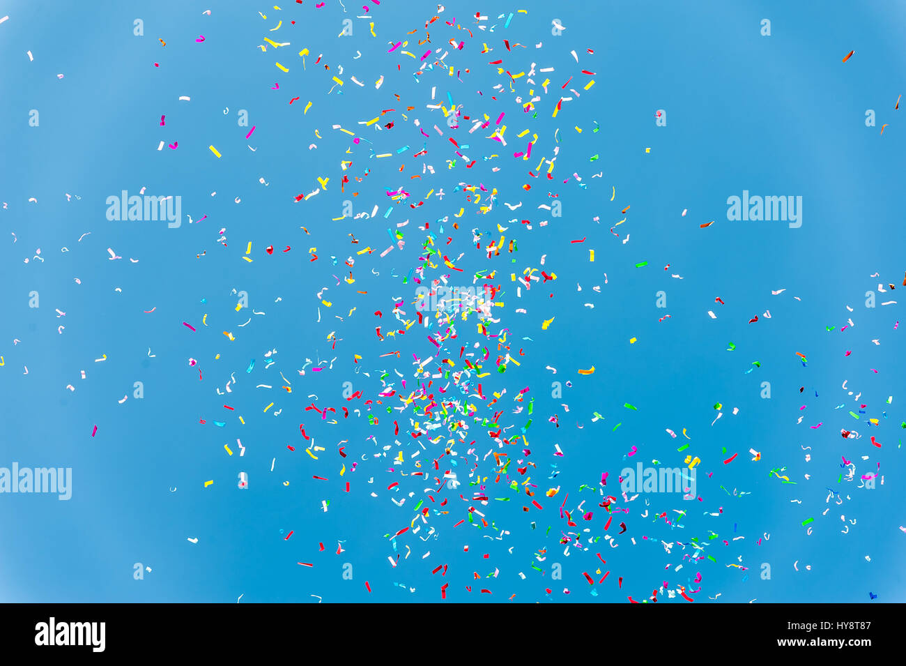 Close up of colorful confetti against a blue sky Stock Photo