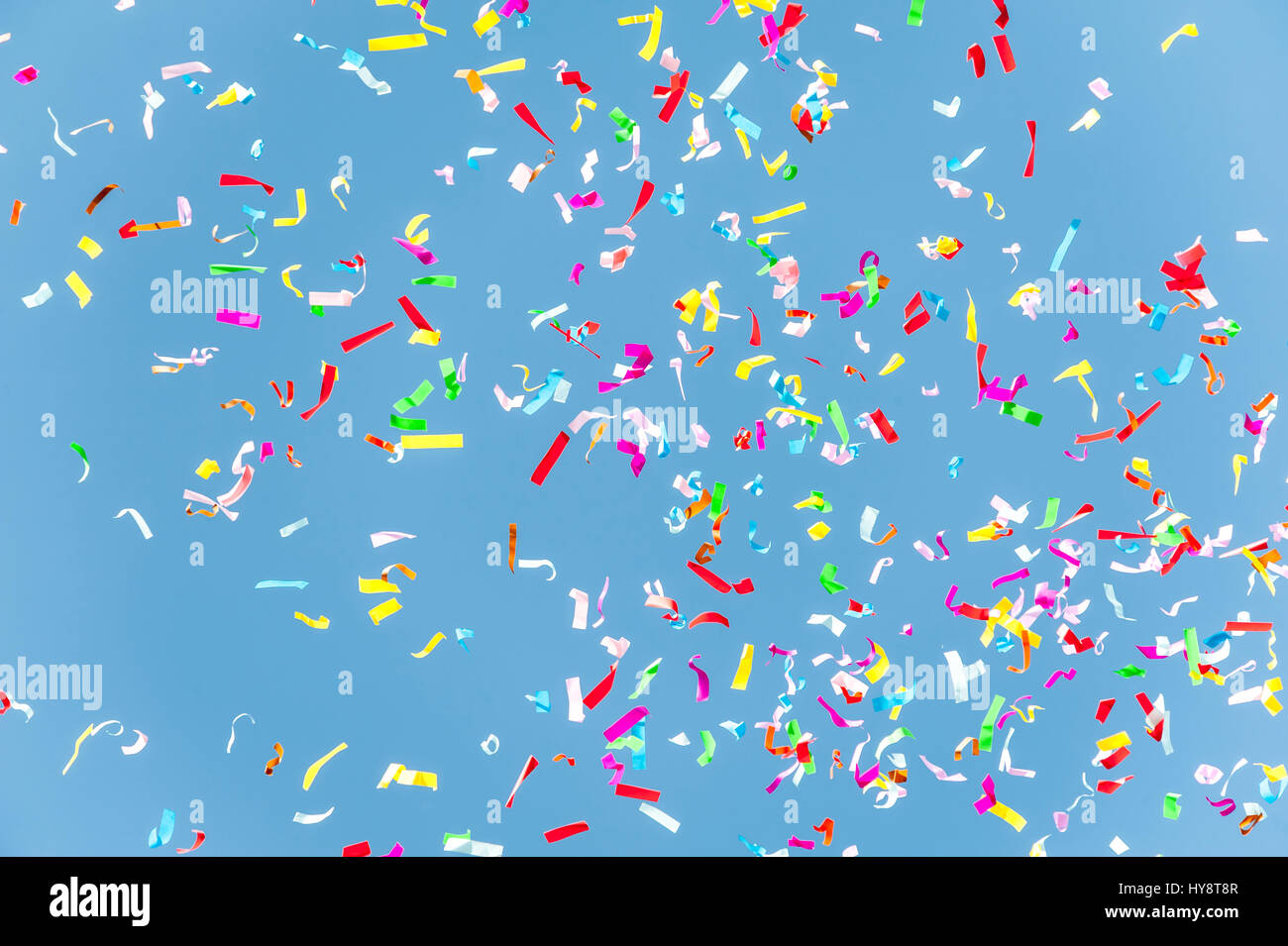 Close up of colorful confetti against a blue sky Stock Photo