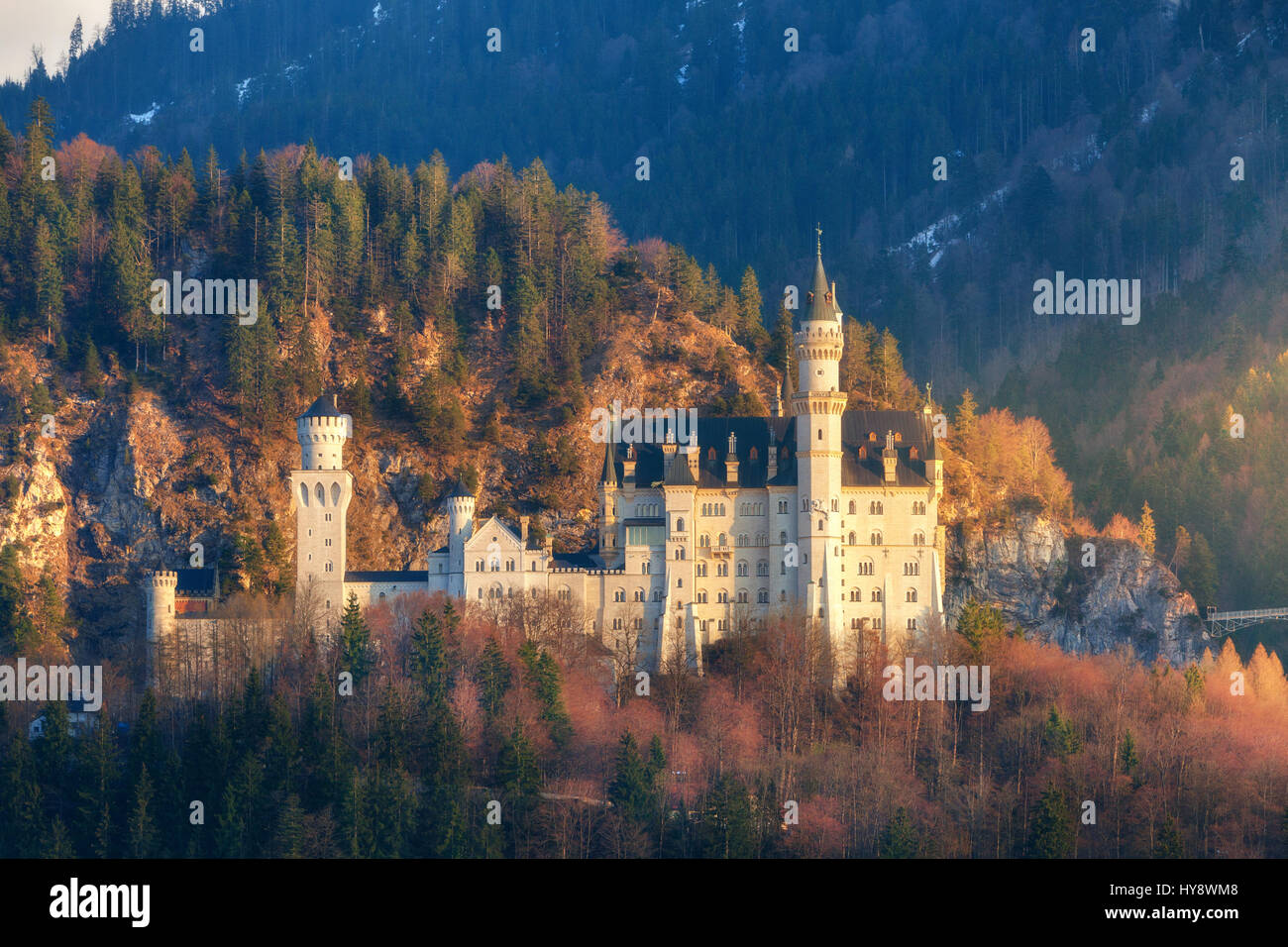 The famous Neuschwanstein Castle on the hill and mountain forest at sunrise in Germany. Amazing colorful spring landscape with castle, mountains, gree Stock Photo