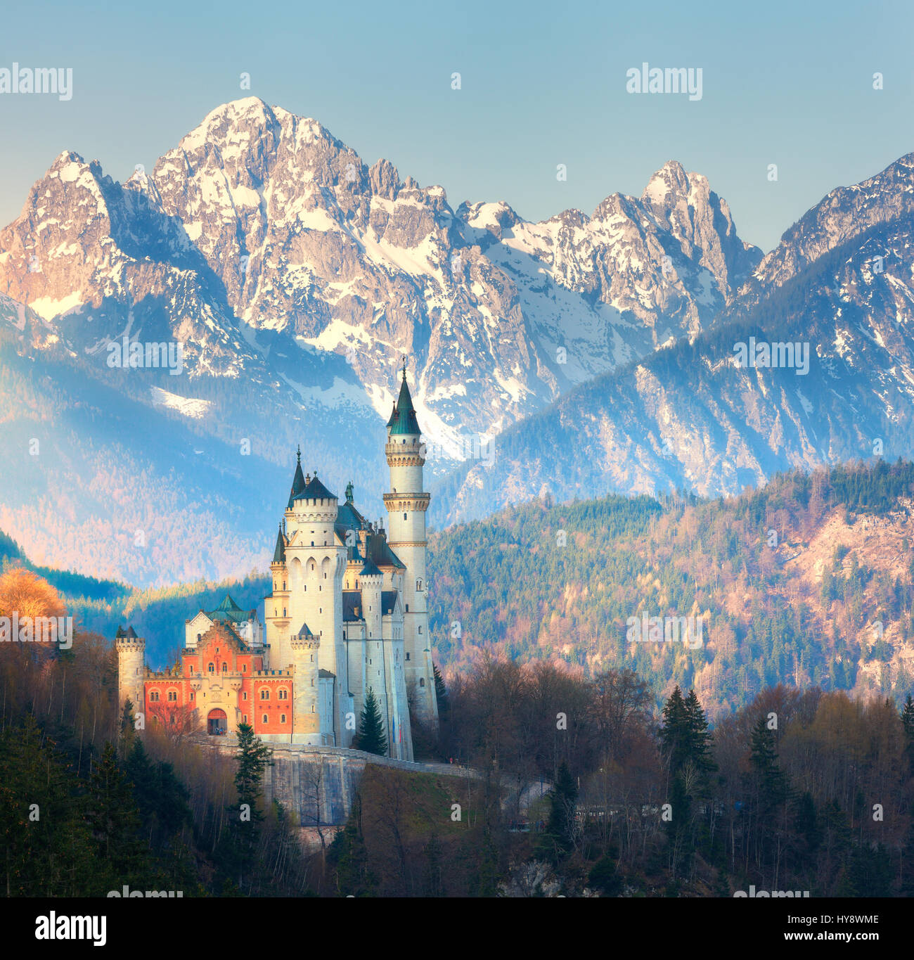 The famous Neuschwanstein Castle in the background of snowy mountains at sunrise in Germany. Beautiful spring landscape with castle, mountain peaks an Stock Photo
