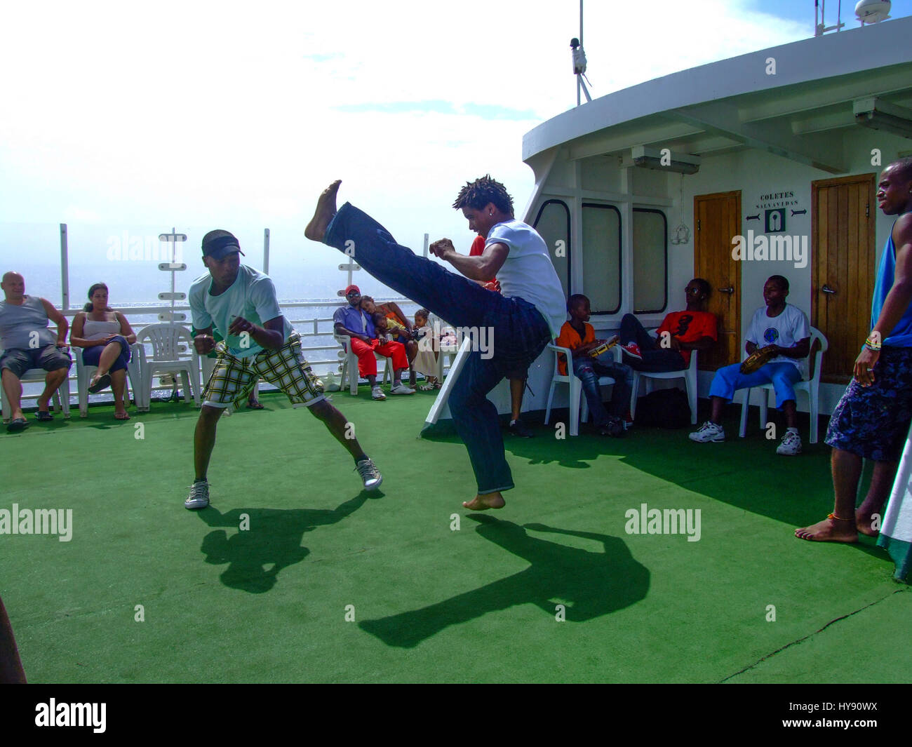 Two young men practice capoeira, a Brazilian martial art form, on the ferry from Santo Antao to