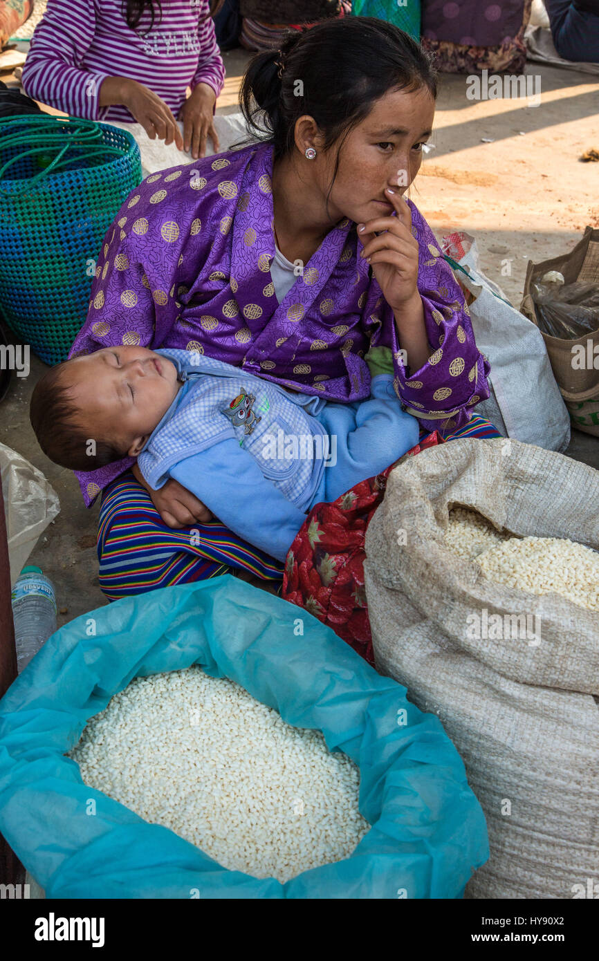 People Selling Rice Woman selling rice in the farmers market in Punakha, Bhutan as her baby ...