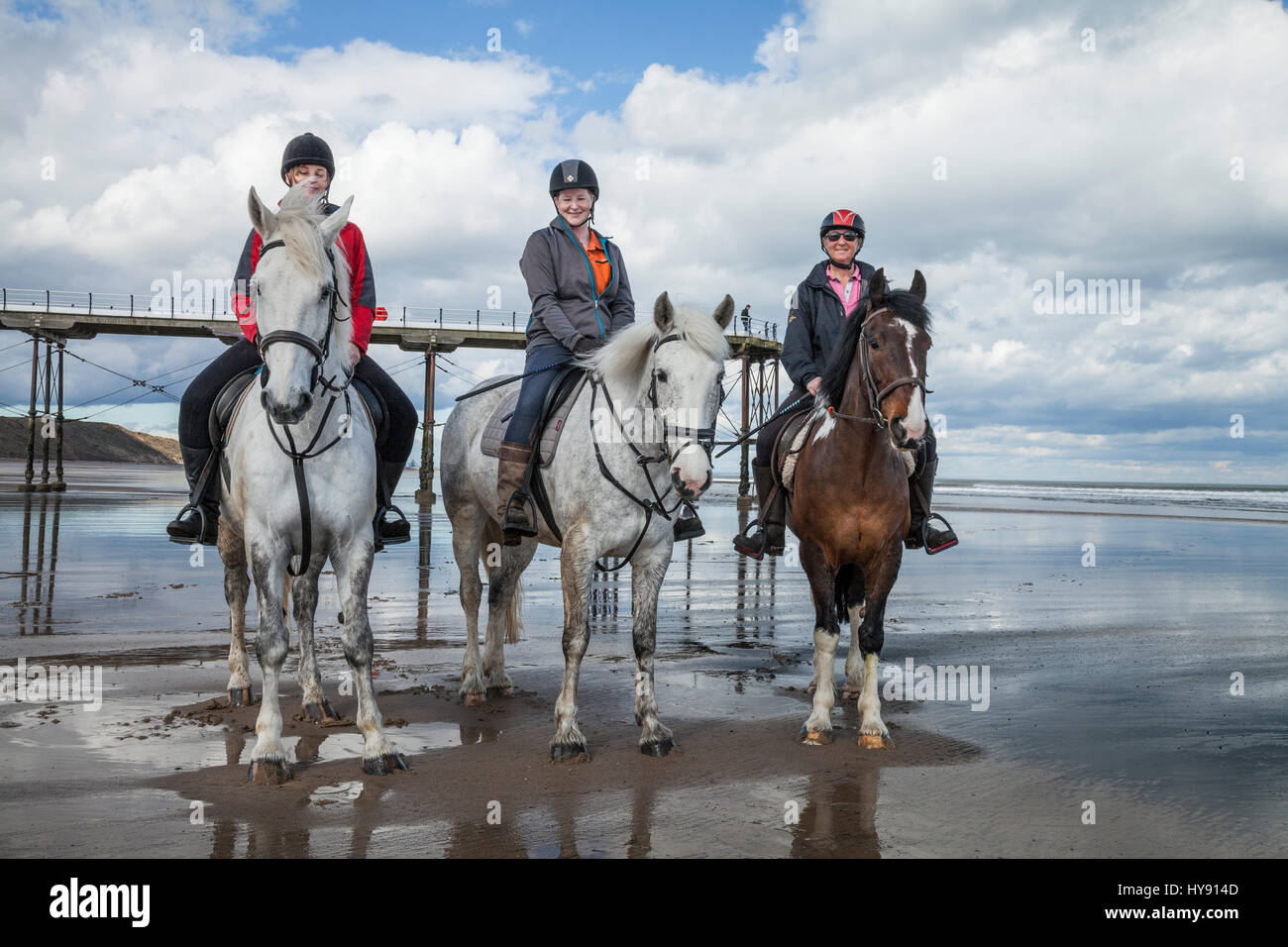 Three women on horseback at Saltburn beach on a bright sunny day Stock ...
