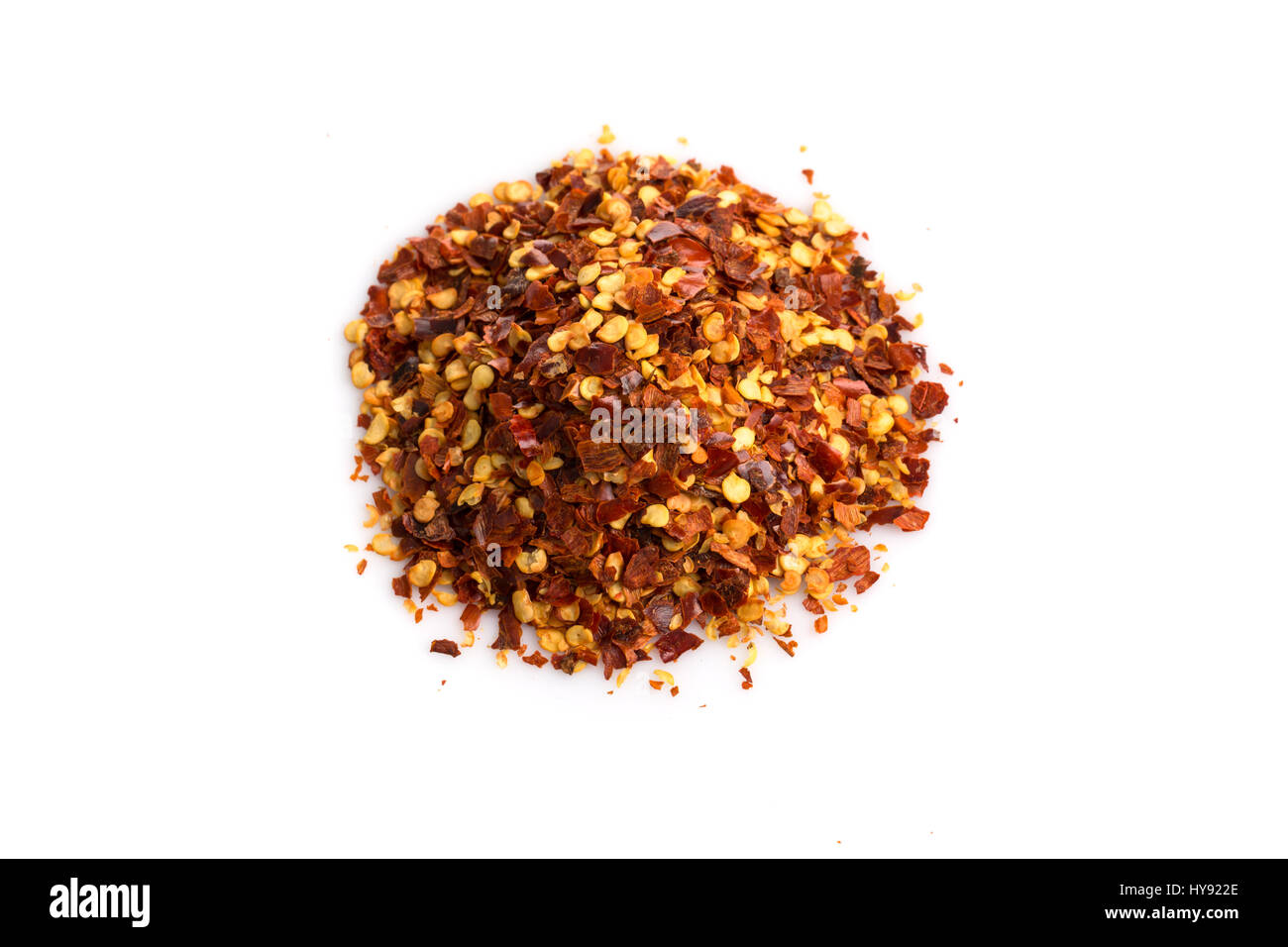 The pile of a crushed red pepper, dried chili flakes and seeds isolated on white background