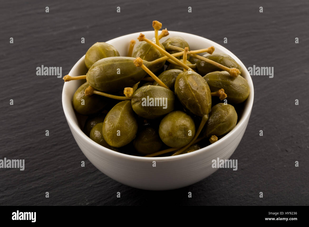 Bowl of canned capers on a dark background Stock Photo - Alamy