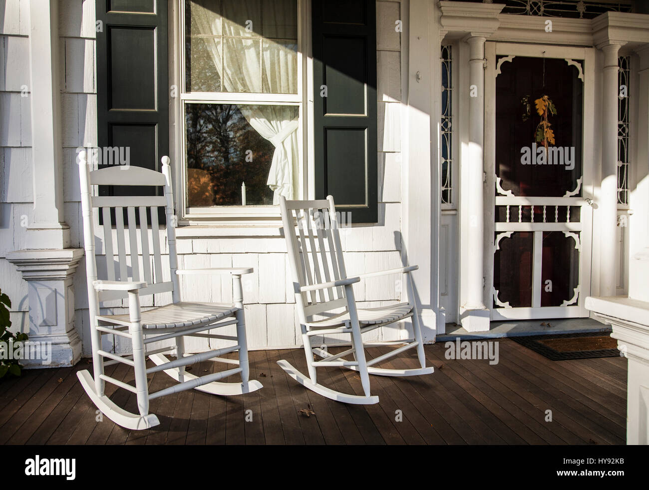 Old fashioned front porch, two white rocking chairs, window and white autumn door, old country farm house, Monmouth County, Freehold, New Jersey, USA Stock Photo