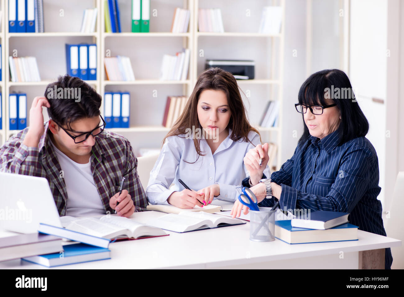 Young student and teacher during tutoring lesson Stock Photo - Alamy