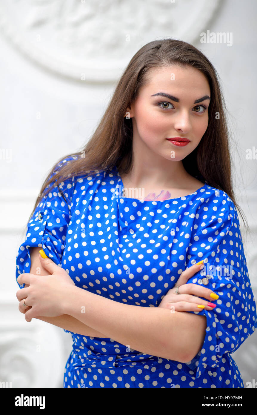 Business woman portrait with crossed arms in blue dress on white vintage  background. Young female model. Stock Photo