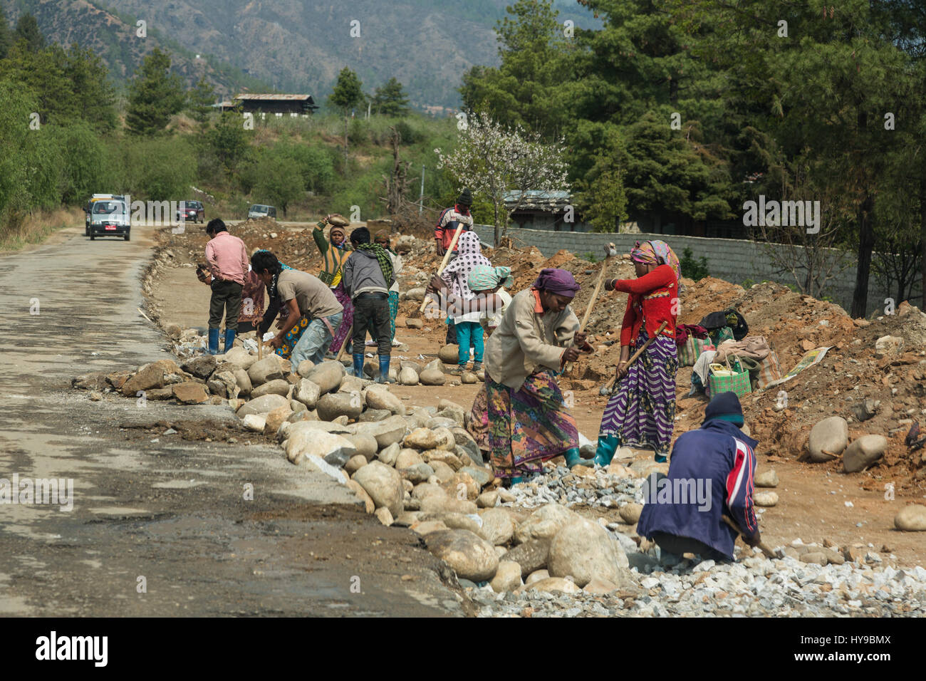 A crew of Nepalese or Indian women work with sledgehammers, breaking