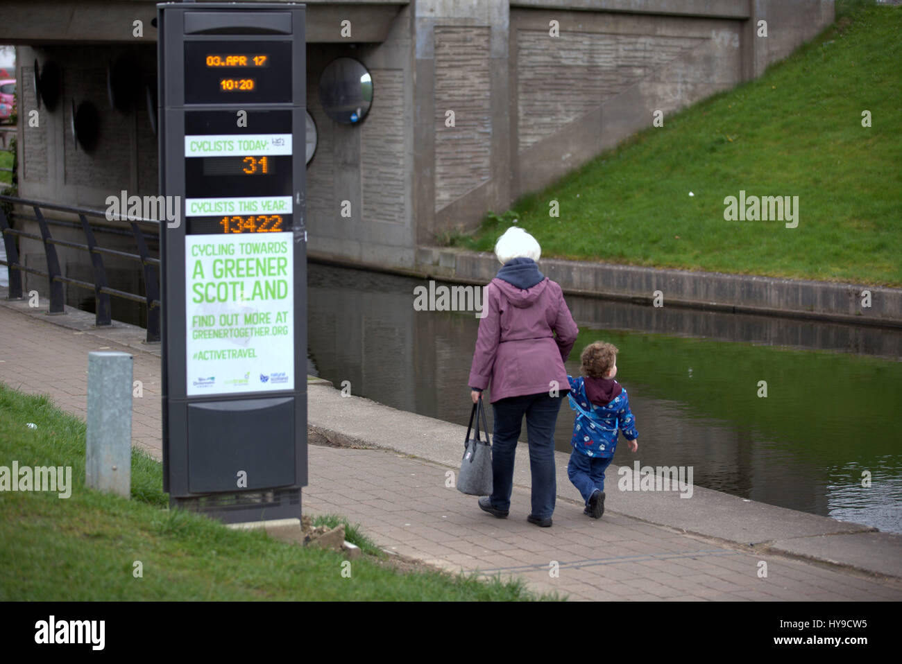 greener scotland #activetravel passing pedestrians  granny and grandchild on the forth clyde canal cycle path Stock Photo