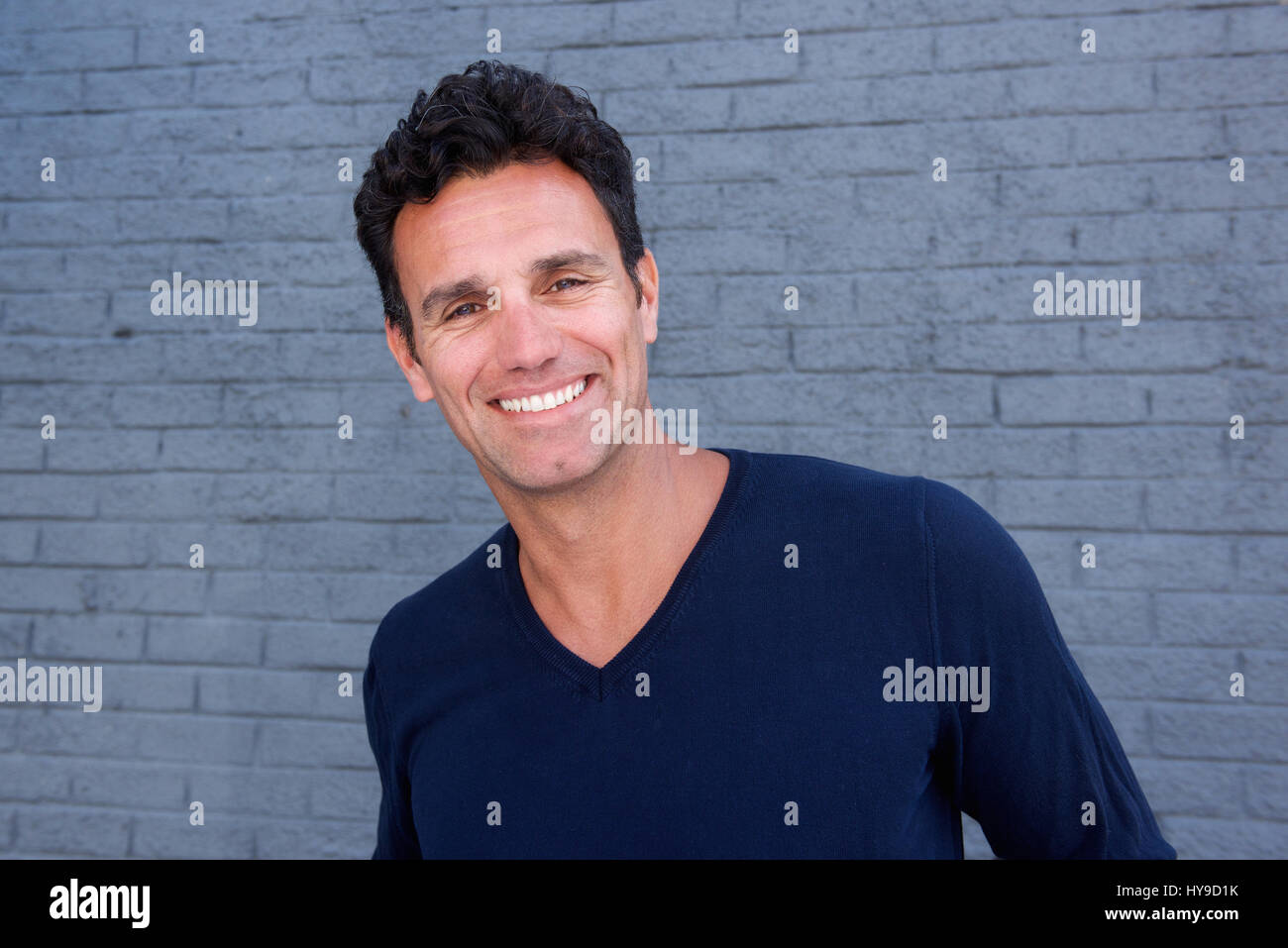Close up portrait of a handsome guy smiling against gray wall Stock ...