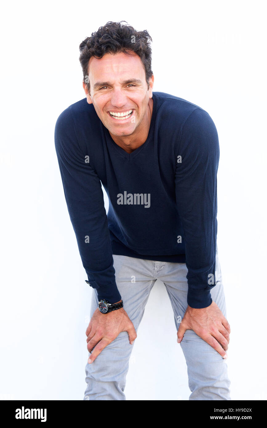 Portrait of a handsome middle aged man laughing with hands on knees Stock Photo