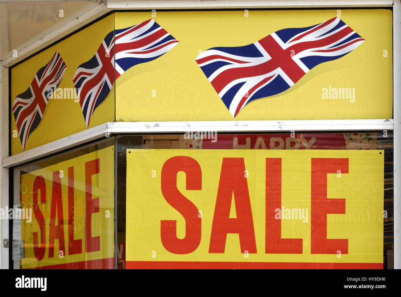 Large Sale sign with illustrations  of Union Jack flag in window of a retail shop closing down for business in a british high street UK Stock Photo