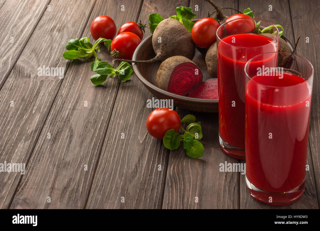 Healthy eating, dieting and vegetarian concept - glass juges of beet-tomato juice with vegetables on dark wooden background . Detox and healthy diet . Stock Photo