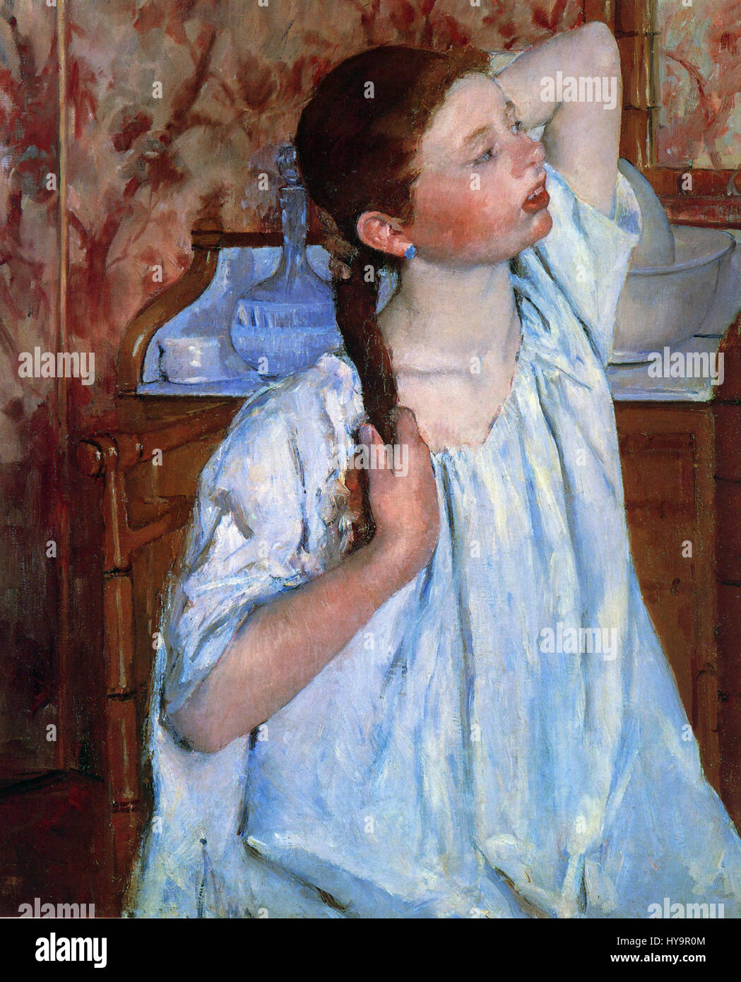 'Girl Arranging Her Hair' by Mary Cassatt depicts a young woman engaged
