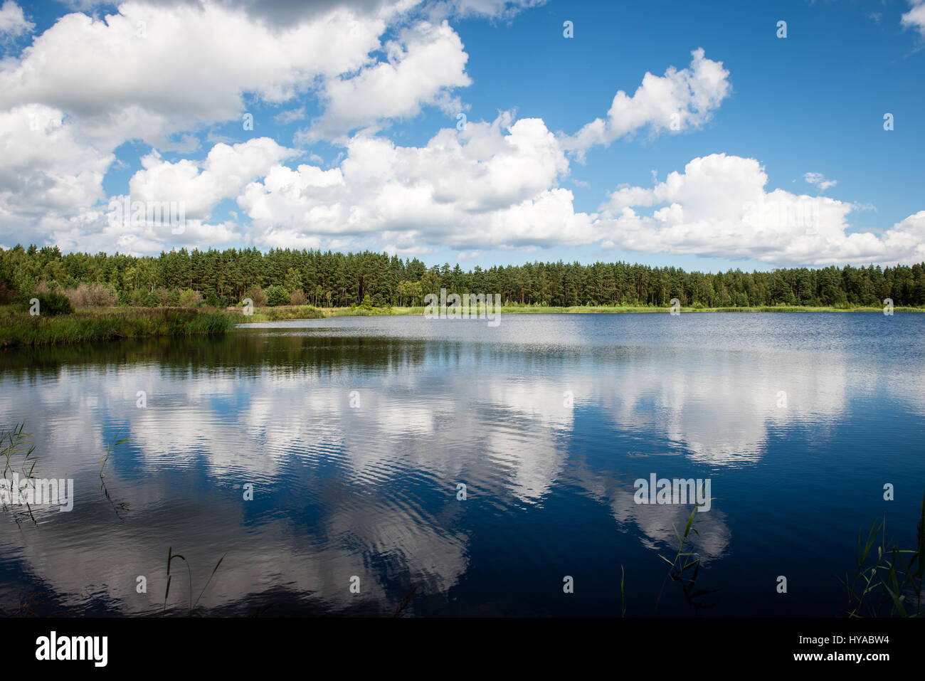 reflections in the lake water at sunrise with clouds and dramatic ...