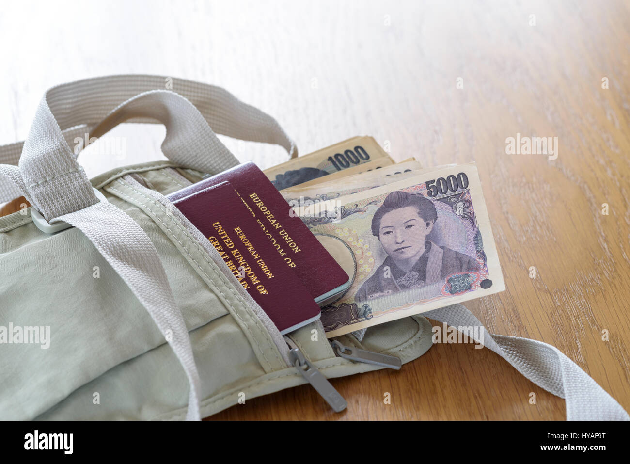 Shoulder holster money belt, with cash and passports.Japanese currency ,Yen, laid out on a table. Stock Photo