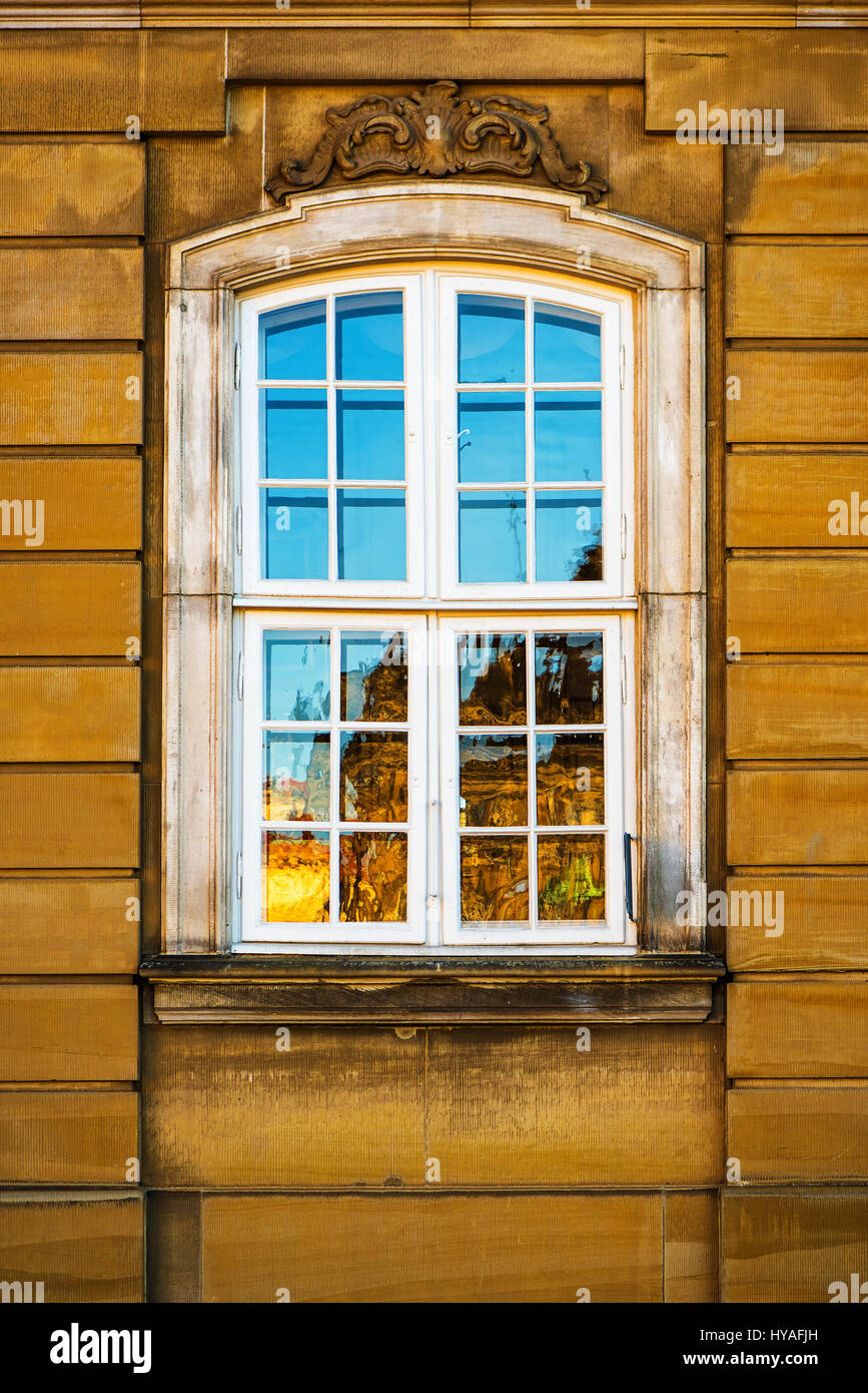 Old white window and yellow building facade, architectural style typical for Nordic countries, captured in Copenhagen, Denmark Stock Photo