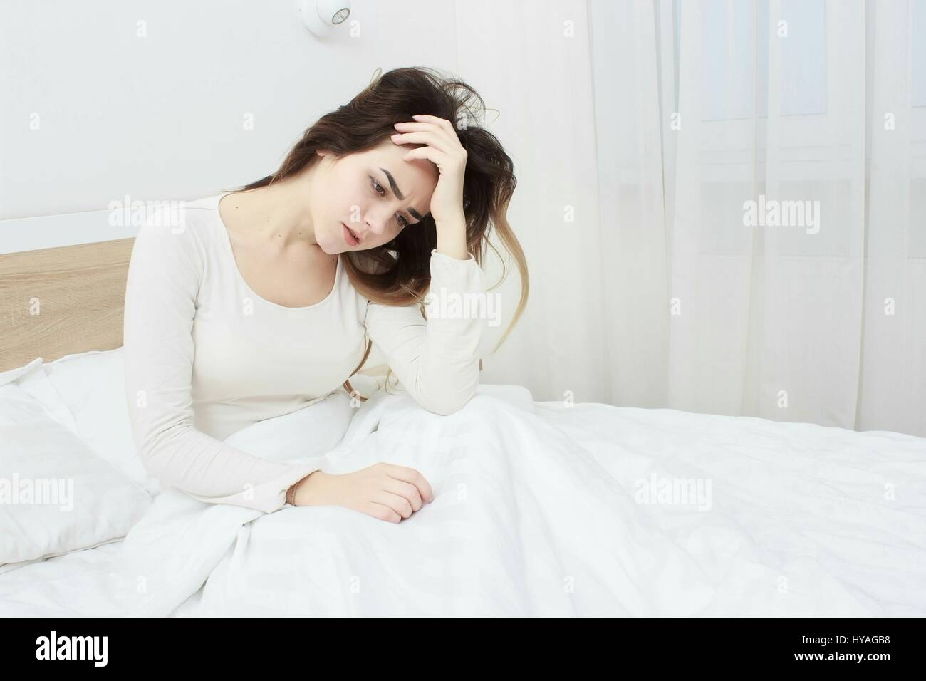beautiful girl has woken up in the morning in bed in a bad mood Stock Photo  - Alamy