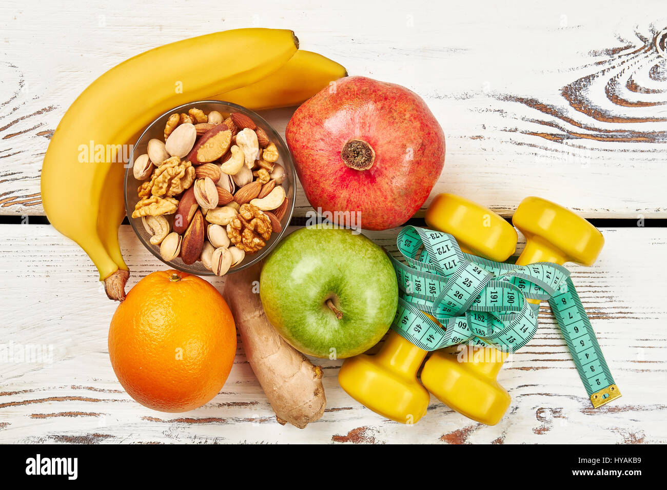 Fruits, ginger, nuts and dumbbells. Health is a treasure Stock Photo