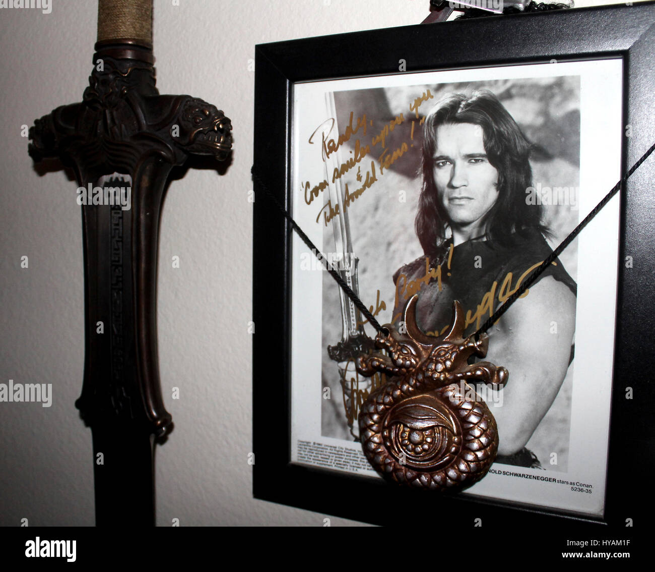 SACREMENTO, CALIFORNIA: Schwarzeneggar superfan Randy Jennings shows off his Conan sword and picture. THE WORLD’S number one Arnie superfan is celebrating his muscle-bound hero’s 67th birthday by revealing his Schwarzenegger shrine for the first time. From the carefully tending to his USD80K (£45K) collection of Arnold Schwarzenegger memorabilia to spending hours managing 90,000 new followers per month at his Arnie’s Army fansite – one superfan has made it his life’s mission to the Total Recall of his all-time idol. Since he was just eleven-years old and watched the legendary Arnie movie, Cona Stock Photo