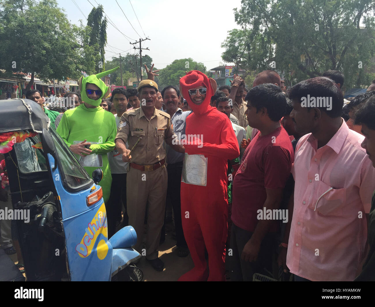 Tyler Newman (left) and Sean Newlan (right) pose with a policeman and local people. THREE BRITONS are saying E-OH to the Subcontinent by taking on the eccentric challenge of crossing India on a rickshaw dressed as the iconic children’s television characters the Teletubbies. Driving 2,000miles on pothole infested dirt roads from the “Golden City” of Jaisalmer in the state of Rajastan to the station of Shillong in the Himalayas pictures show how locals responded to the wacky-costumed trio who hope to raise £30K for a women’s refuge in Bangladesh. Led by estate agent Sean Newman (47) and joined b Stock Photo