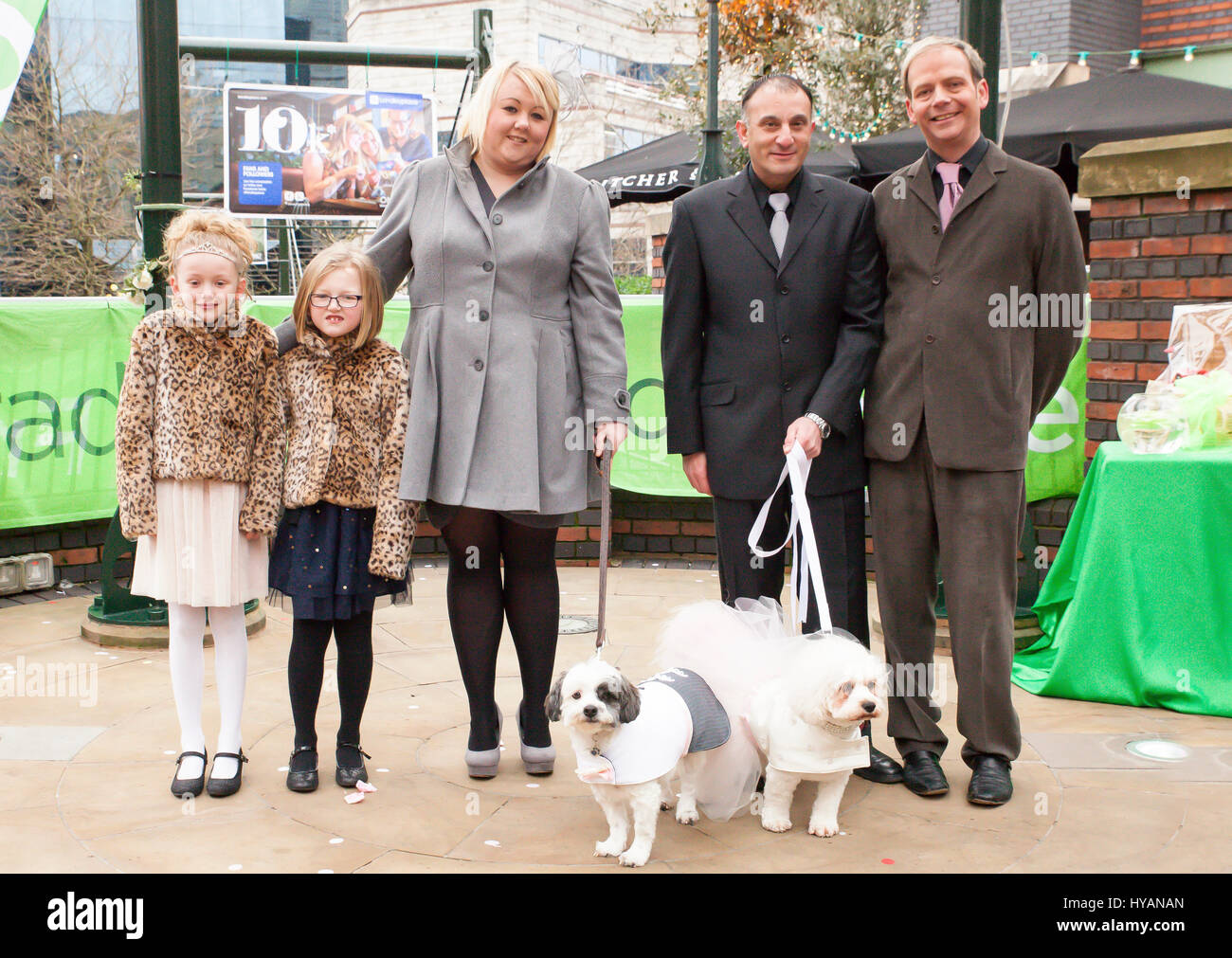 Brindley Place, Birmingham: From left to right, Beccy Haywood holding dog rufus and her two dauthers, co-owner George Michael and Graham Riley holding his dog Lady. A DOGGY wedding could be the most whirlwind yet as former lonely-hearts Rufus and Lady get hitched after dating for just THREE-WEEKS. Pictures show how love-up Bichon Frise Lady (3) and Cavachon Rufus (2) were walked up the aisle by their owners and were married to the delight of 60 human and canine wedding guests. Despite the speed of their relationship the setting couldn’t be more romantic – with the UK’s only pet registrar Ann C Stock Photo