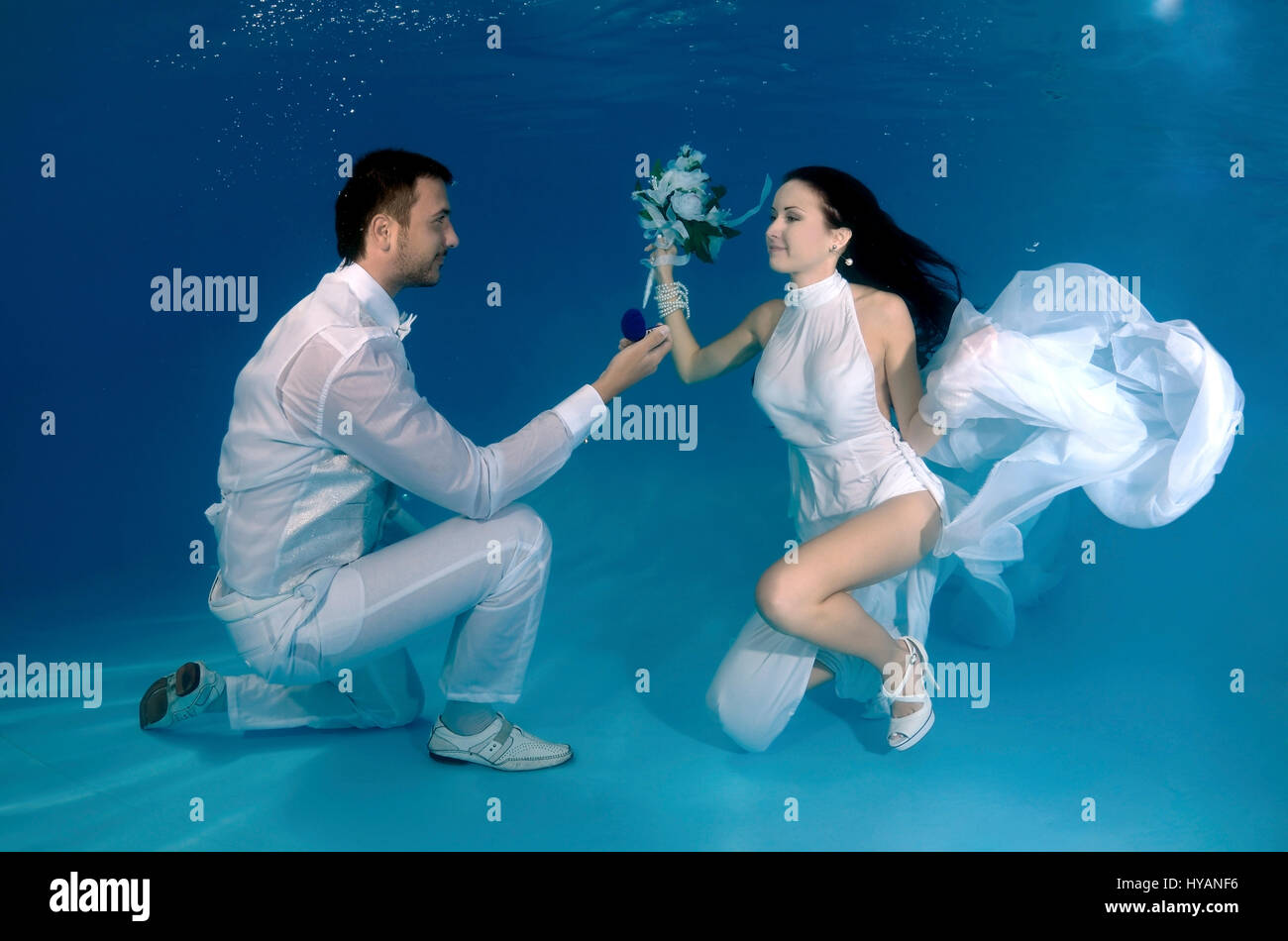 ALL ROUND EXCLUSIVE. ODESSA UKRAINE Bride and groom pose for underwater snap showing the proposal. NEWLYWEDS are literally taking the plunge when it comes to commemorating their new marriage. Jumping ...