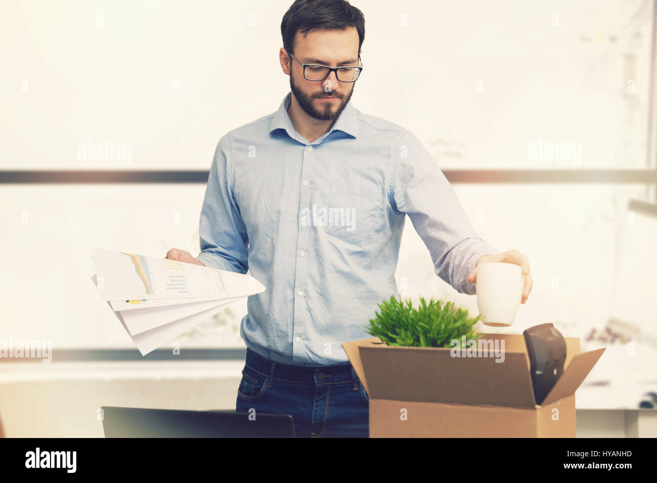 job loss - fired man putting his belongings in cardboard box Stock Photo