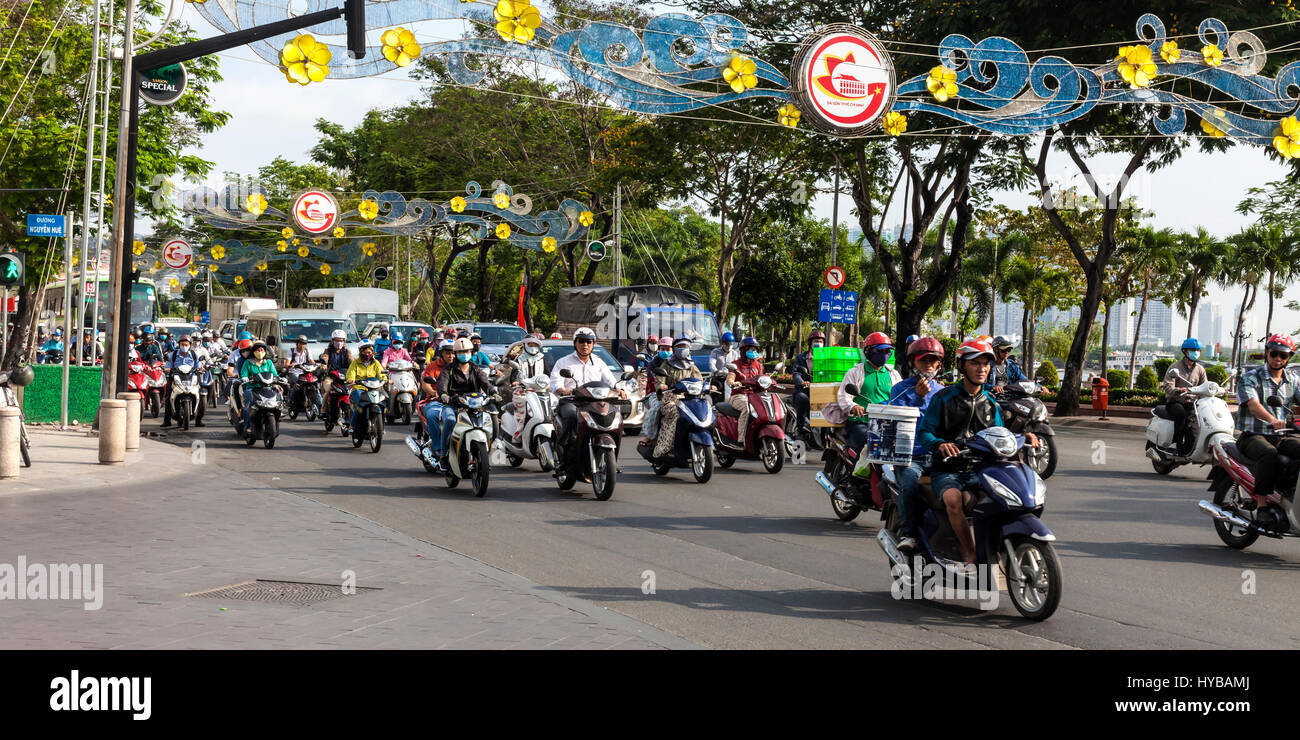 Morning rush hour in Saigon with dozens of motor bikes heading for work Stock Photo