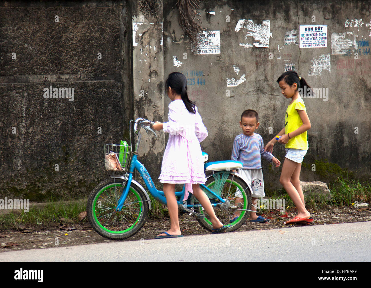 Schoolgirl at Hue prepares to mount her new electric bicycle Stock Photo