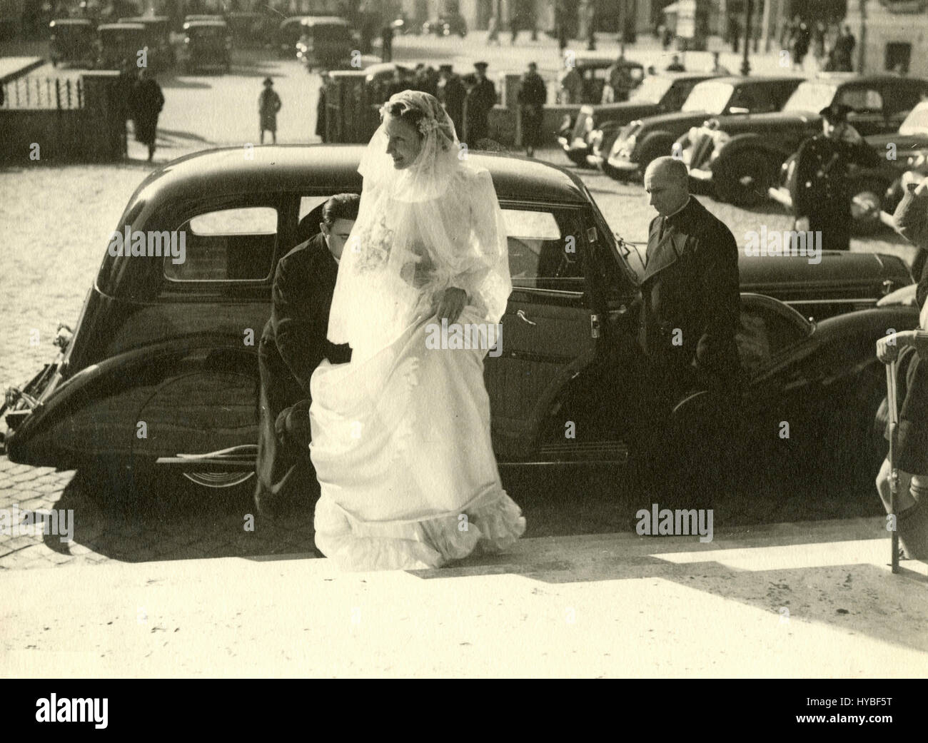 The bride gets out of the car in front of the church, Italy Stock Photo