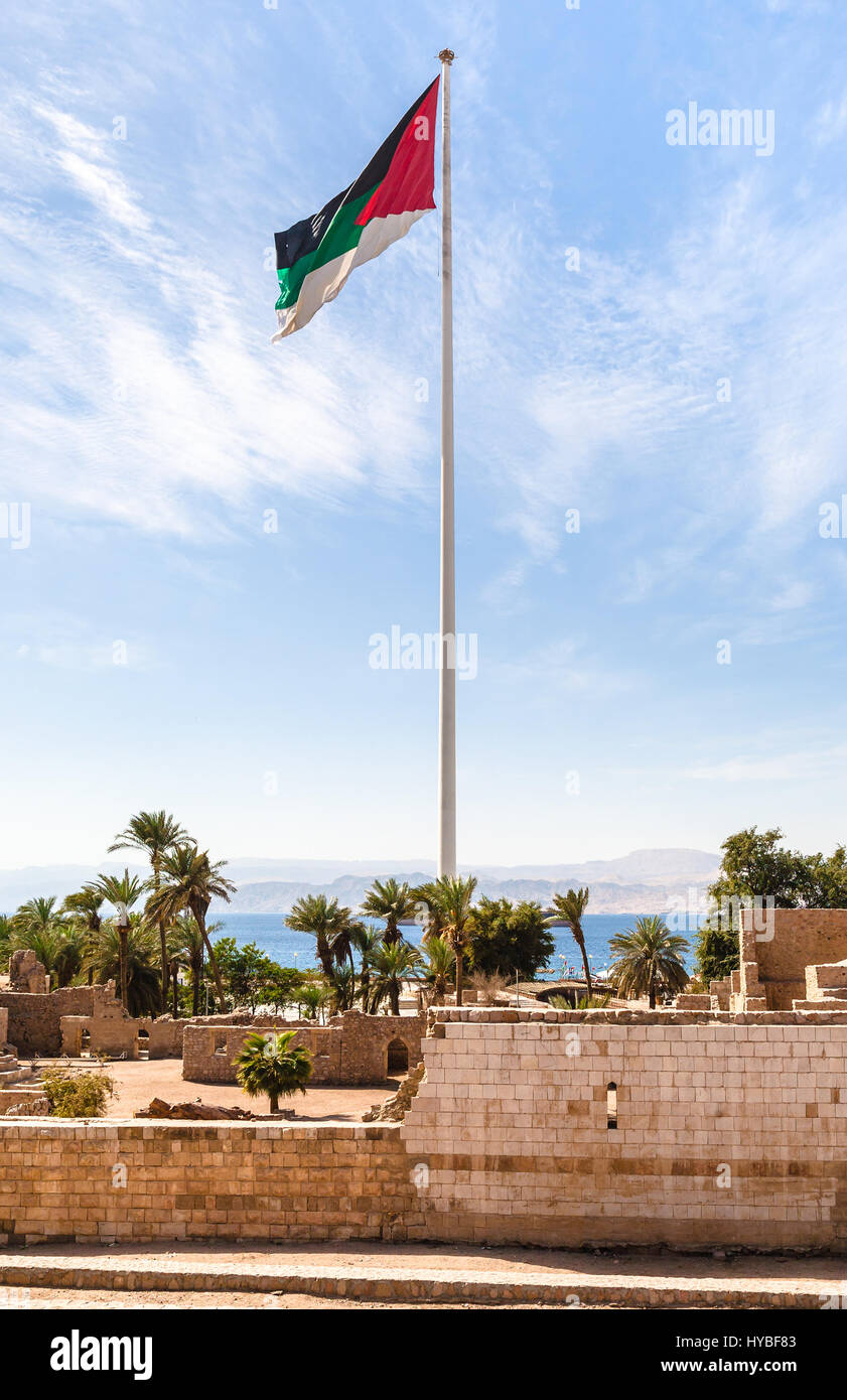 Travel to Middle East country Kingdom of Jordan - Flag of the Arab Revolt over Aqaba Castle in Aqaba city Stock Photo