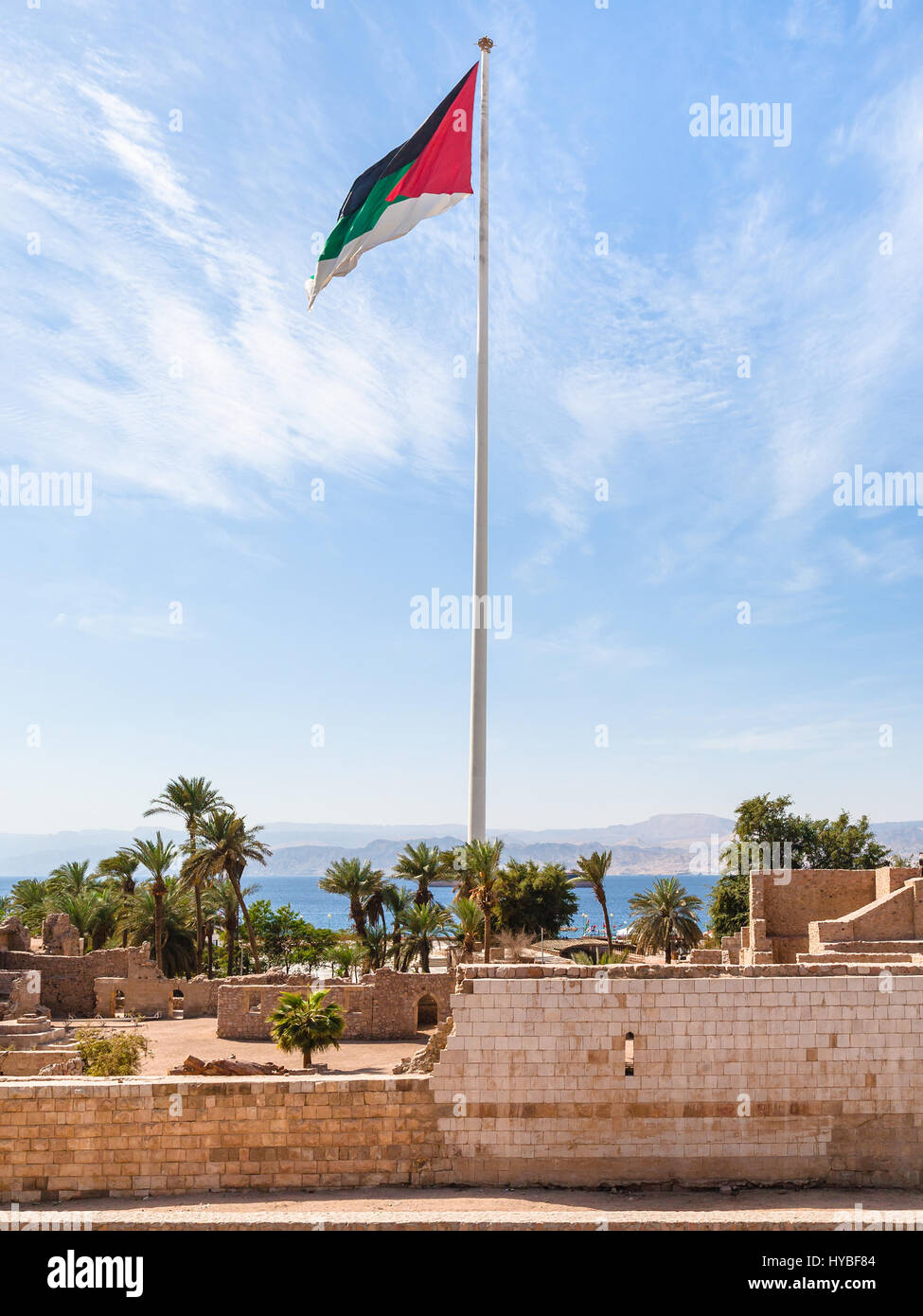 Travel to Middle East country Kingdom of Jordan - Flag of the Arab Revolt over Aqaba Fort in Aqaba city Stock Photo