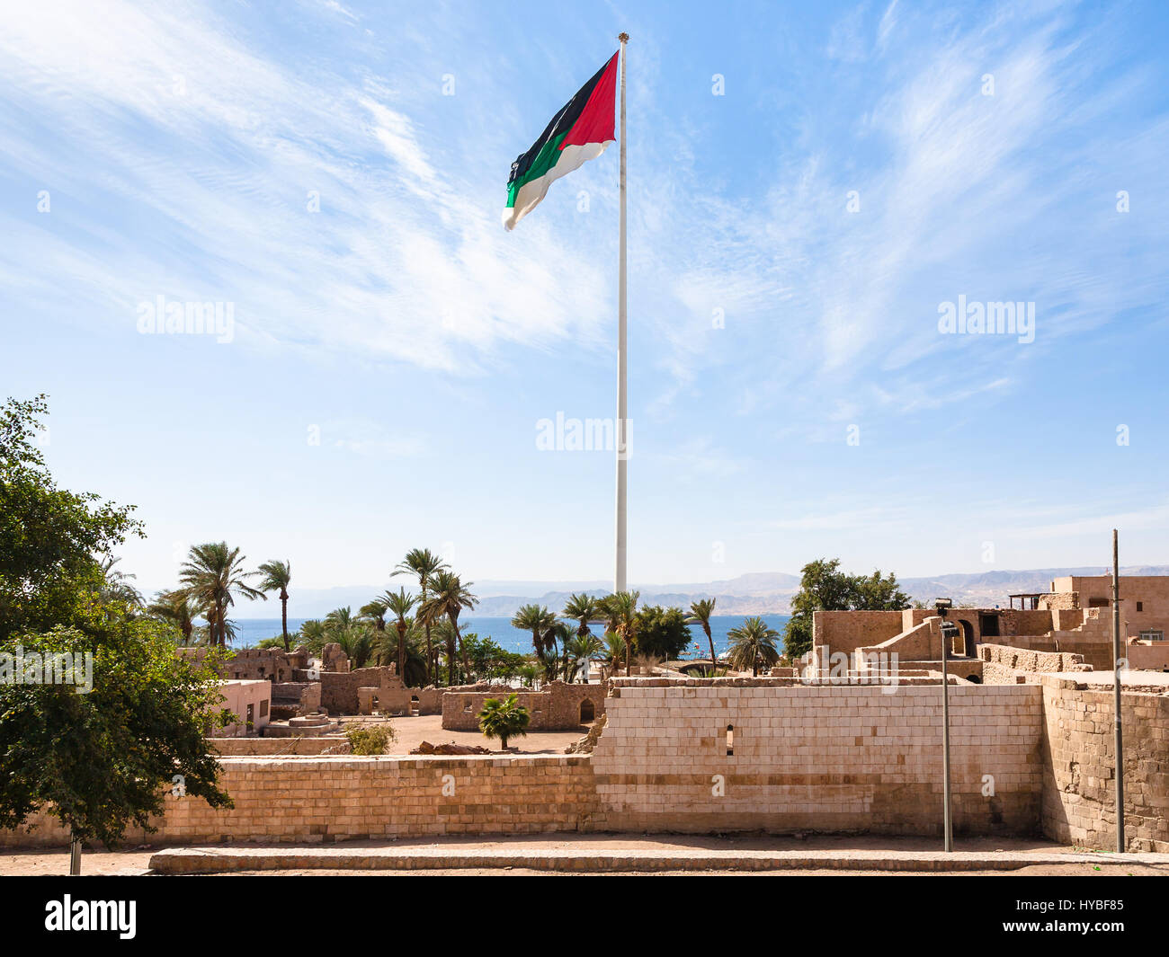 Travel to Middle East country Kingdom of Jordan - Flag of the Arab Revolt over Mamluk Castle in Aqaba city Stock Photo