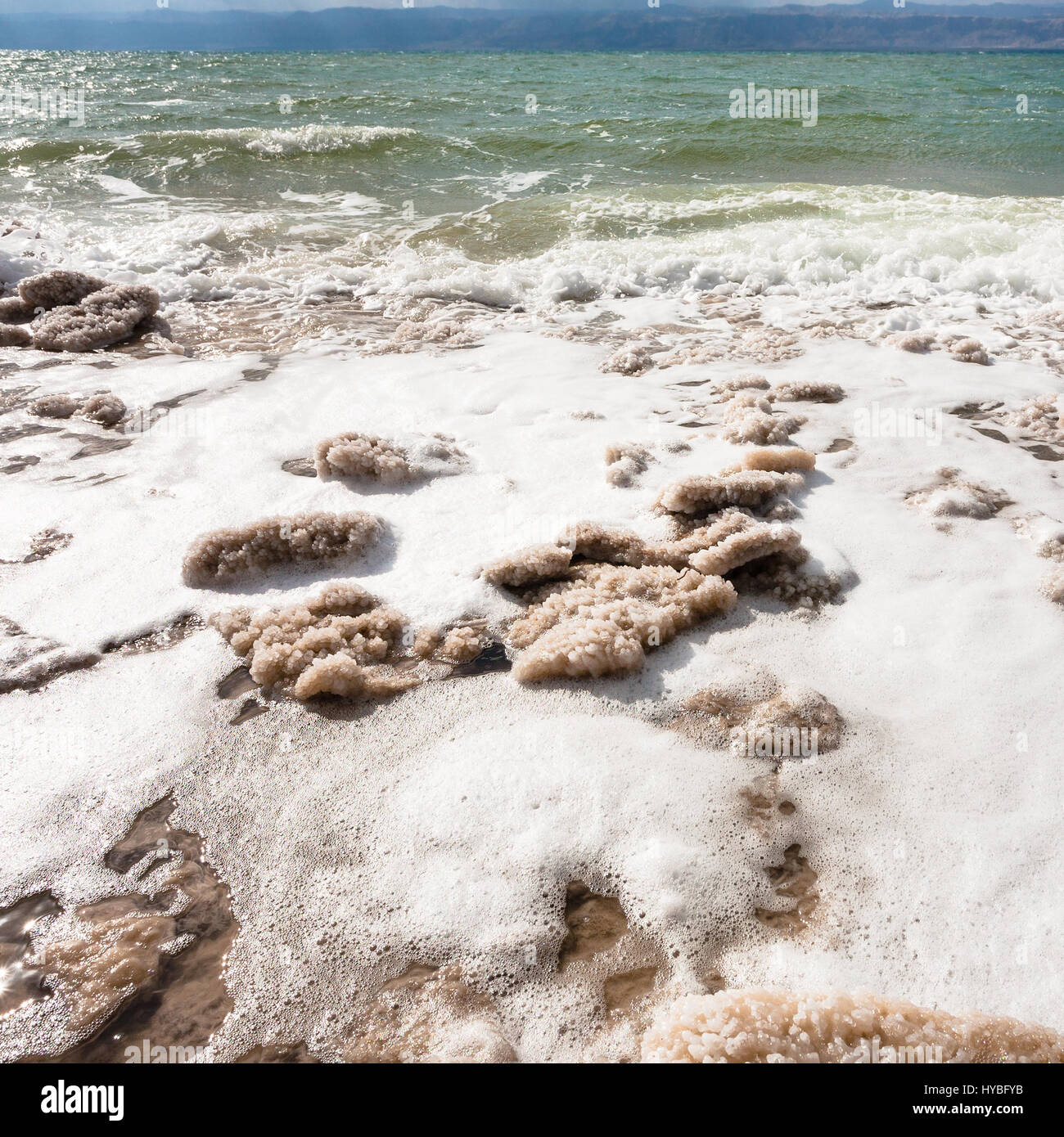 Travel to Middle East country Kingdom of Jordan - pieces of salt crystals on shore of Dead Sea in winter Stock Photo